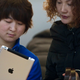 An Apple Store employee shows an iPad2 to a customer in Beijing, China